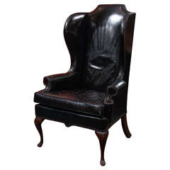black leather wingback chair with touches of red in seat