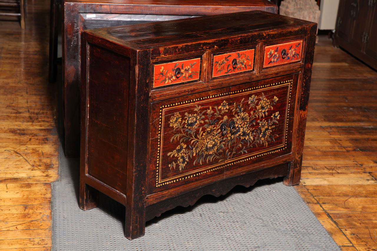A Gansu painted sideboard with three-drawers over two doors delicately adorned with flowers from the early 20th century. This gorgeous sideboard adorned with flowers was made in Gansu, a north central province of China, in the early 20th century. A