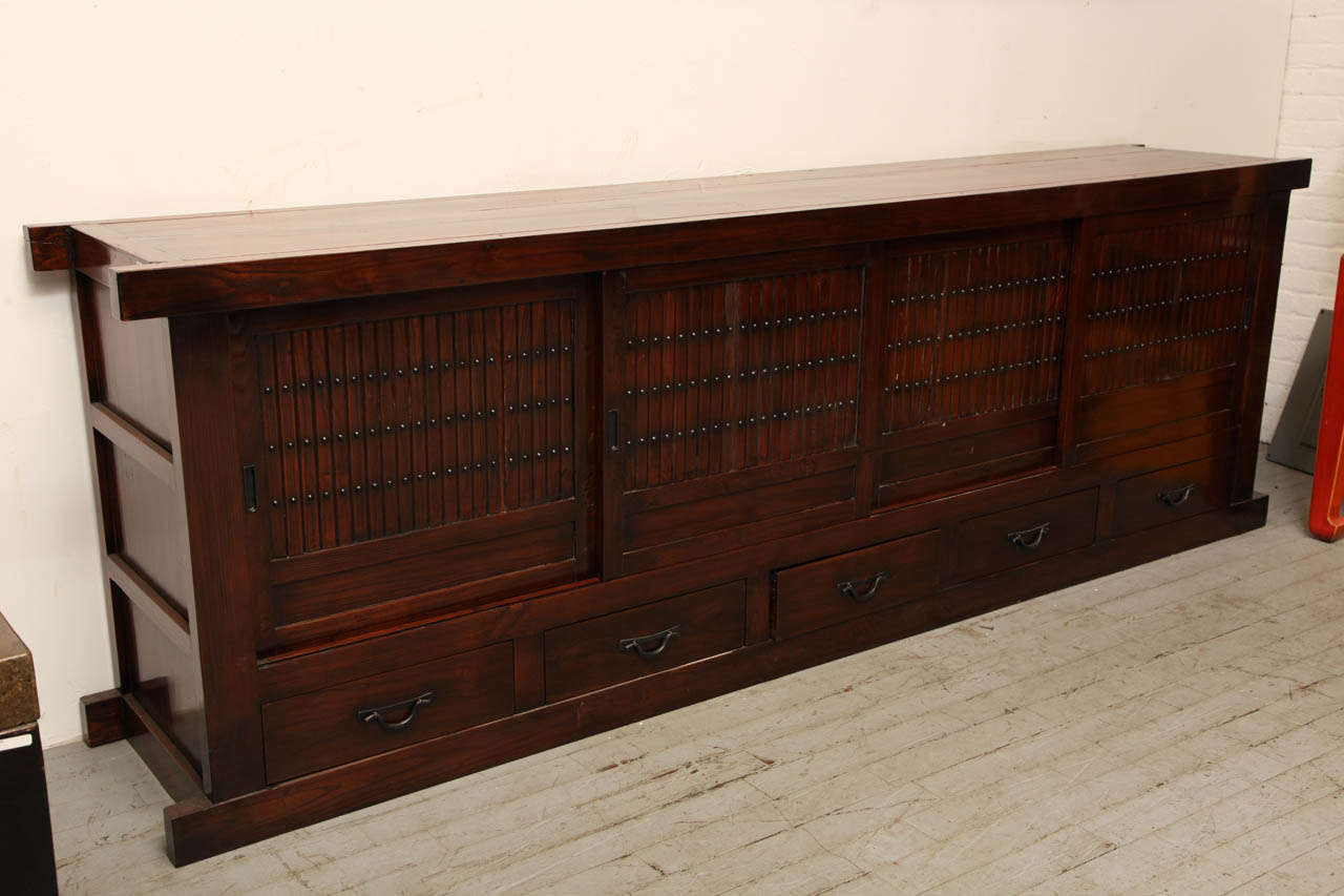 A long elmwood Mizuya Dansu Japanese style long buffet with sliding doors over five drawers. This Mizuya Dansu, a typical Japanese kitchen chest, was made in China during the 20th century from elmwood in a Japanese style. This Mizuya Dansu buffet