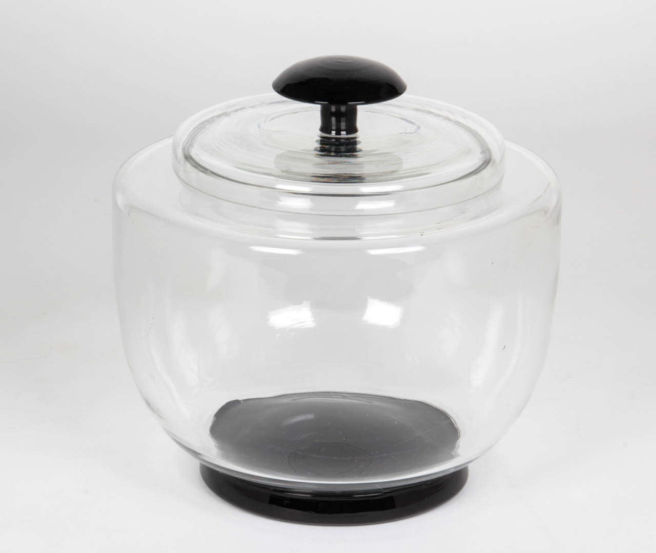 EDWARD HALD  (1883-1980)  Sweden
ORREFORS GLASWERKS  Sweden

Covered crystal jar  c. 1930

Blown clear crystal with applied black glass foot: blown clear crystal lid with applied black glass finial.

For more information and related