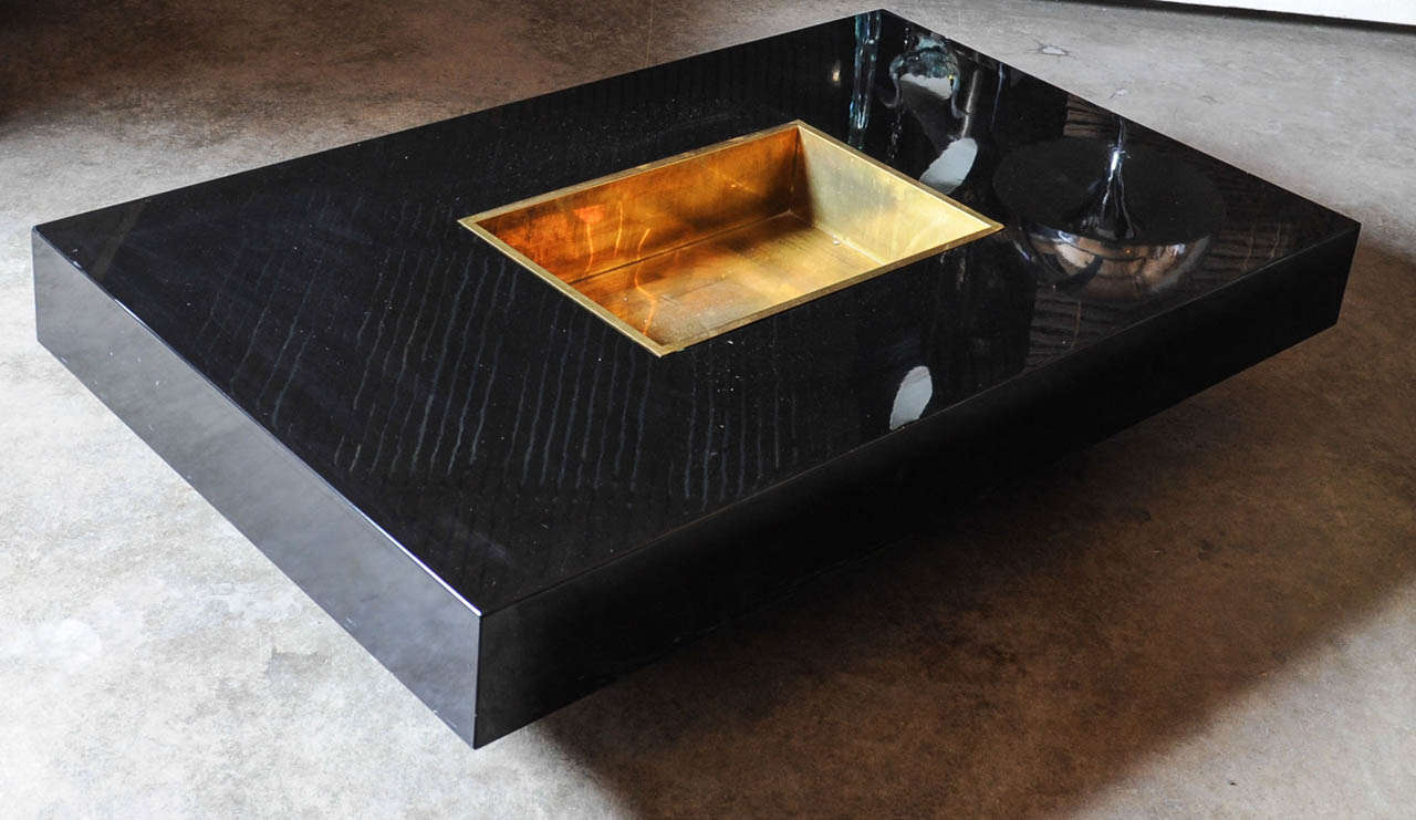 Highly glamorous black lacquered coffee or cocktail table by famous designer Willy Rizzo. The copper basket in the middle can be used for magazines but is ment to put ice cubes in to cool your champagne bottles. Very eye catching piece.