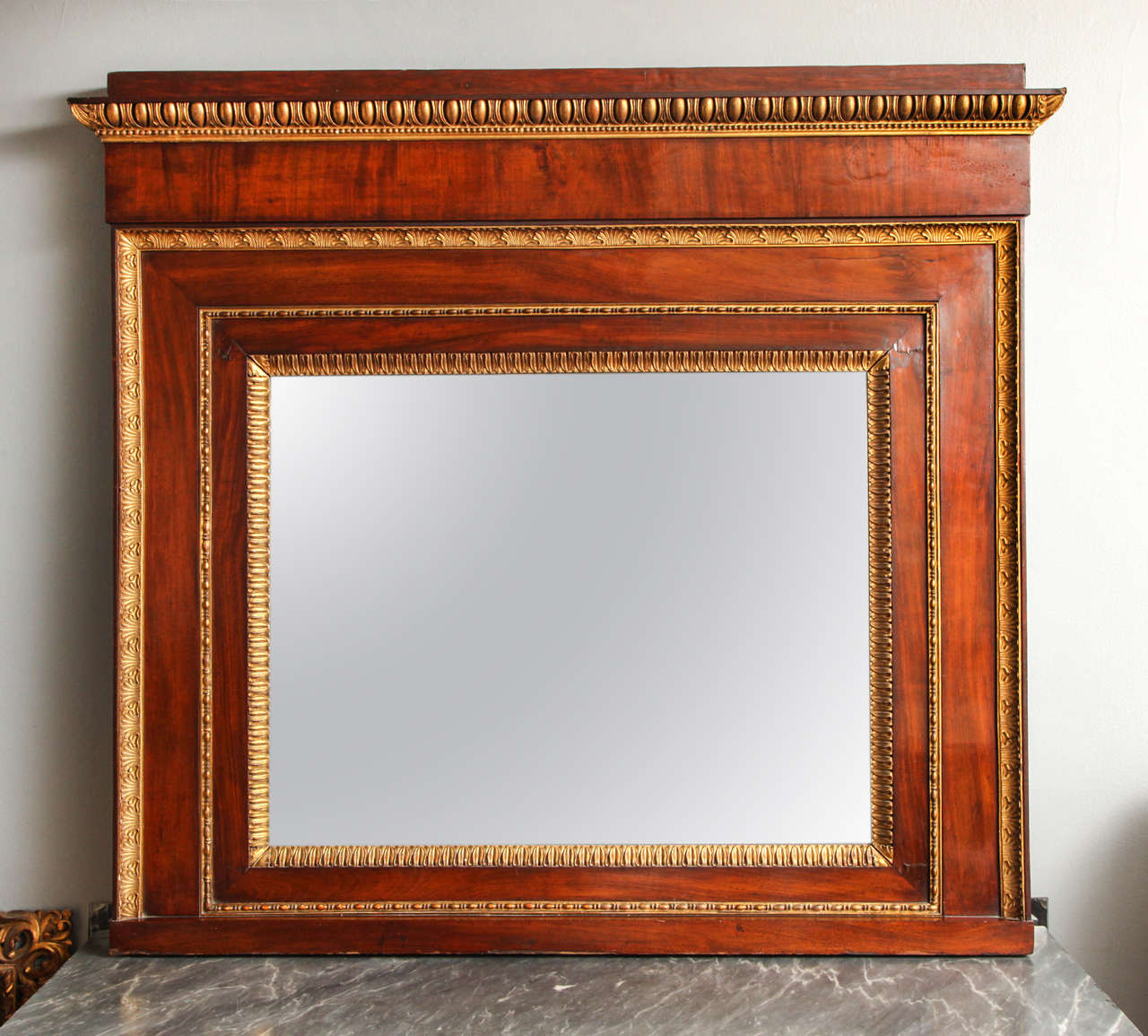 Large northern Italian mahogany and gilt-wood mirror with original glass. Handsome egg and dart, bead and reed, and acanthus details. Overall dimension: 58