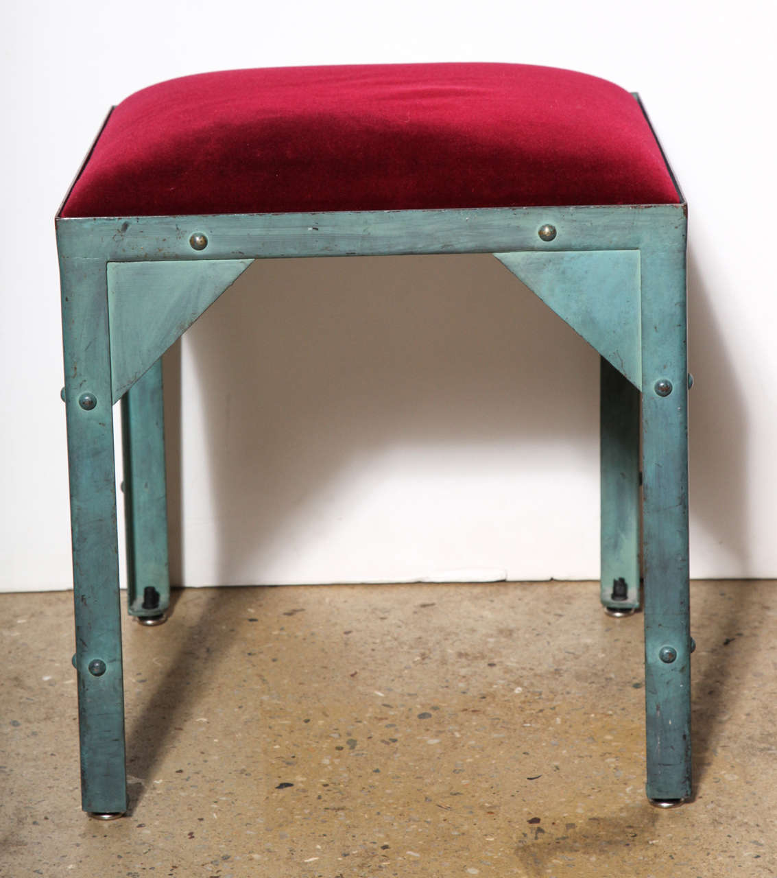 Late 20th Century Jean Paul Gautier Paris Showroom Occasional Stool - Ottoman. Featuring Steel with aqua green verdigris finish and red velvet upholstery, detailed with rounded rivets and triangular corners. Open square framework. Made in France.