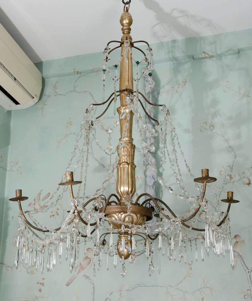 An elegant large-scale three-tier Italian late 18th century giltwood and crystal Genoese North Italian chandelier. The giltwood central column terminates in a finial at the bottom with carvings of acanthus leaves on the central stem. Six large
