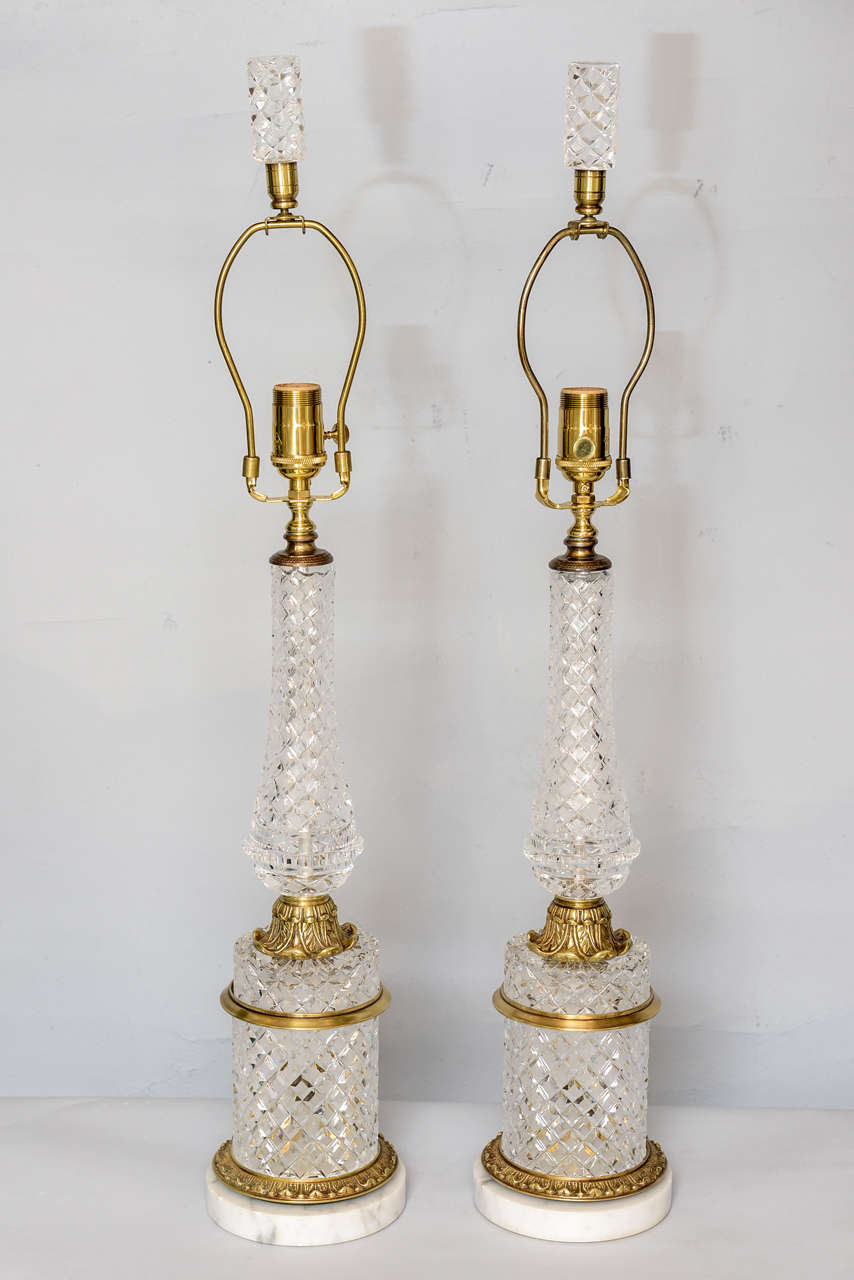 Pair of lamps, each of fine lead crystal, cut in the Baccarat diamond design, in balustrade form, with bronze fittings, raised on round crystal plinth, on Carrara marble base. Matching finial.

Stock ID: D2078