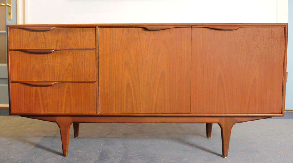 Wonderful elegant organic style compact sideboard by the great furnituremakers of McIntosh from Kirkaldy in Scotland. It has 3 drawers of which the upper one is a cutlary drawer and two swinging doors with a shelf behind