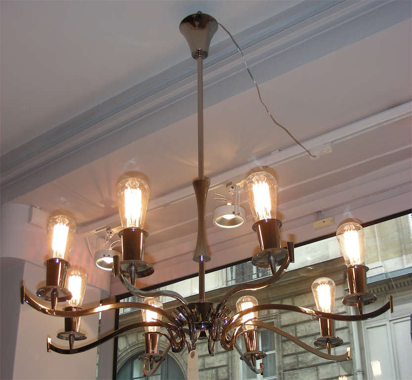 A striking nickel-plated chandelier featuring eight arms bearing bare lightbulbs. (Perfect as shown for faux-vintage bulbs, providing warm light and adding visual interest.)