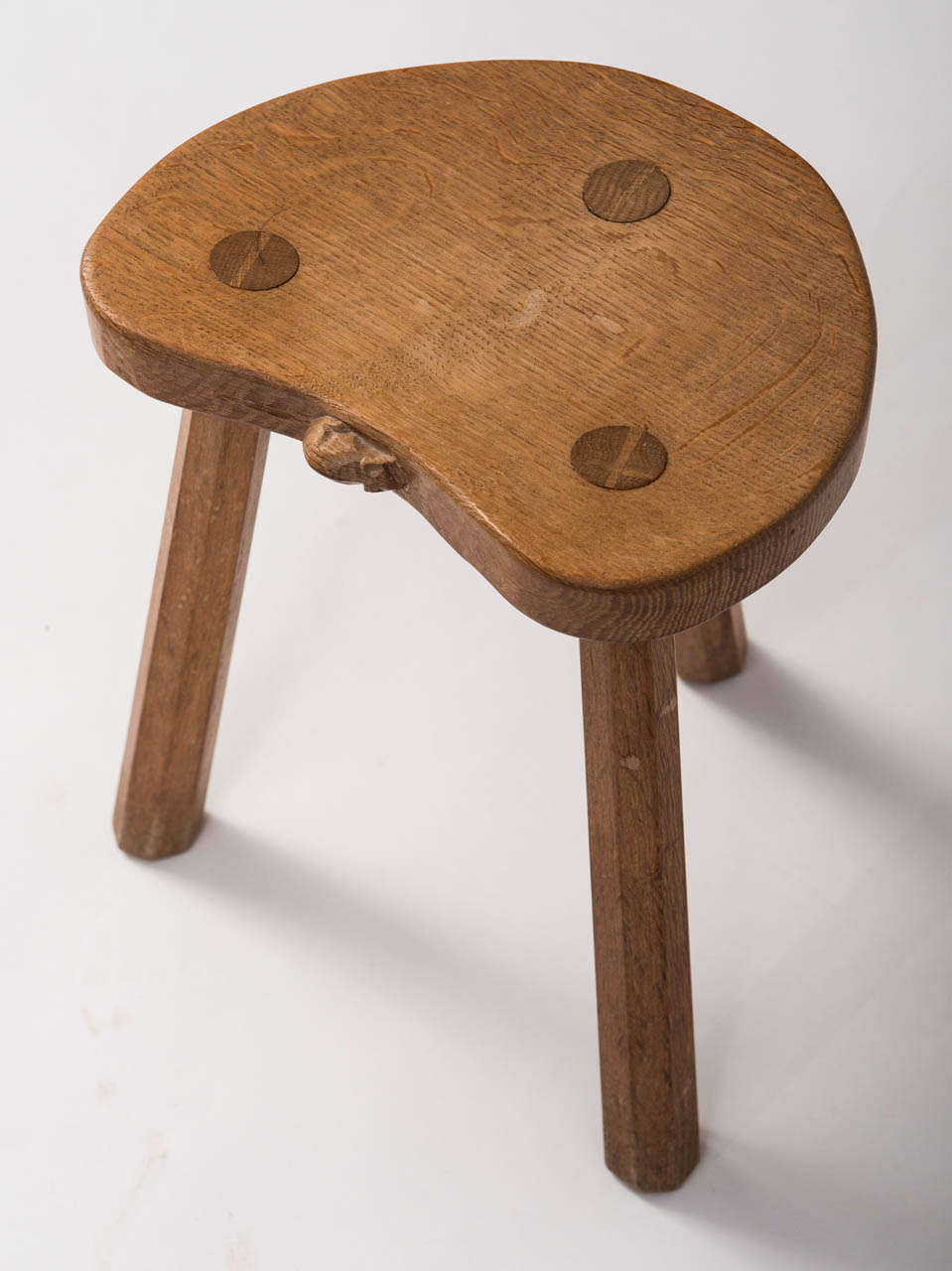 A Robert Thompson “Mouseman” Milking Stool.
Adzed kidney seat supported on octagonal legs.
Oak
Carved mouse 
English
Circa 1970
36cms x 30cms x 25cms