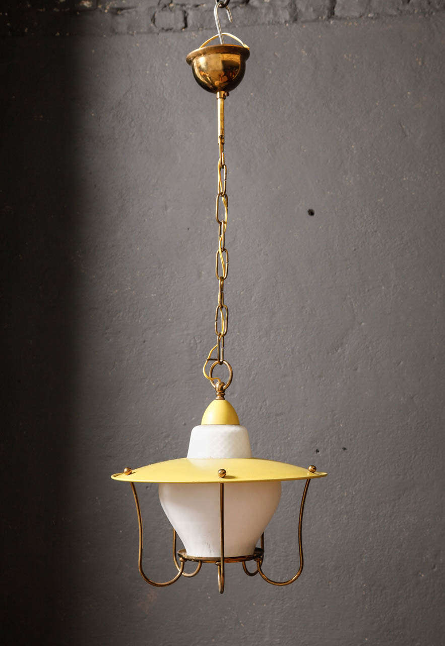 This stunning French pendant light from the 1950s features an brass frame, opaline glass and yellow enameled shade. Light glows from within the ribbed glass shade.