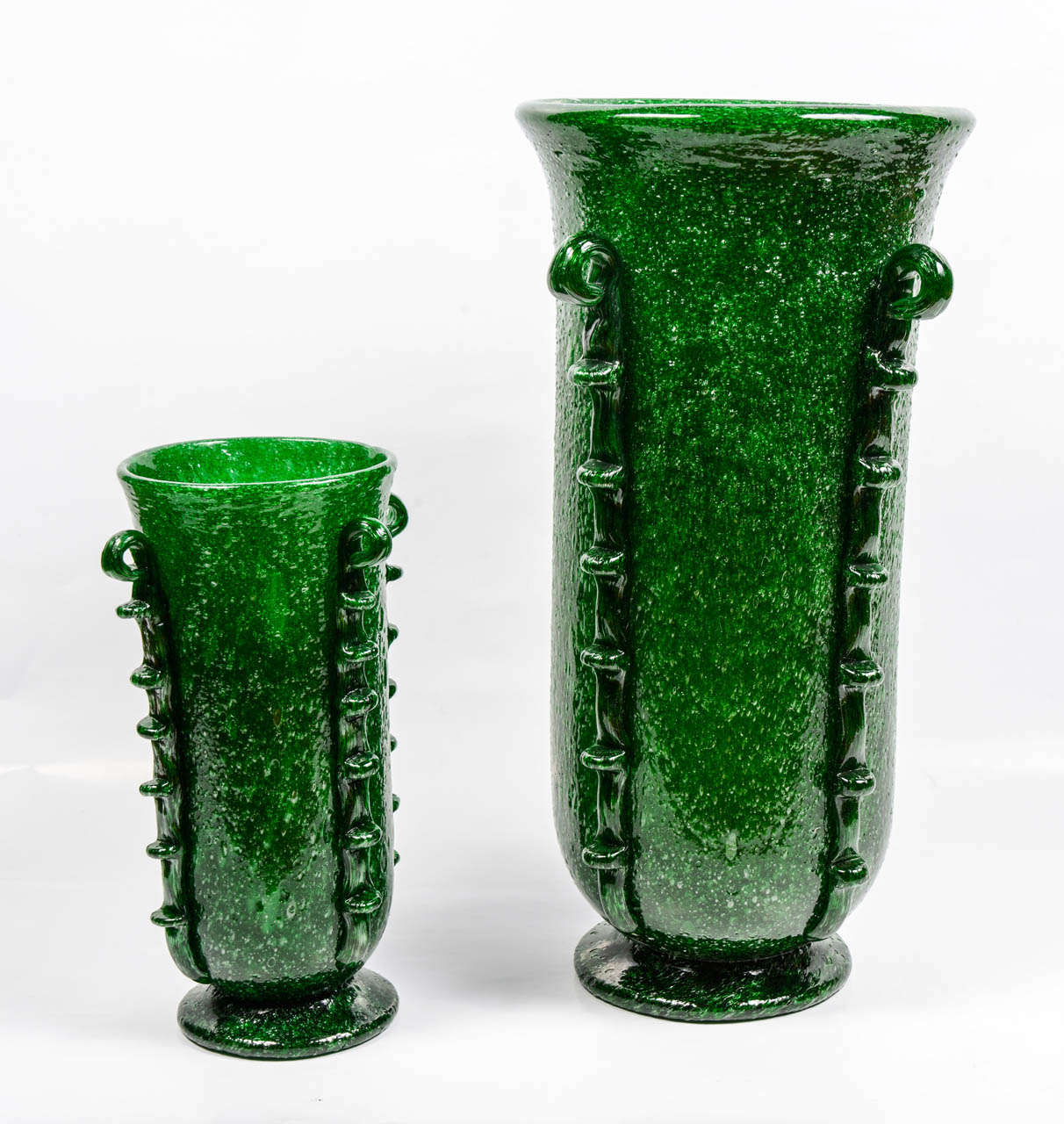 These vases are the design no. 3282 created by Napoleone Martinuzzi during the early 1930s.
Made of a green bubble glass which provides them an interesting texture.
Each of the four vertical bands features ring-shaped decorations and tooth like