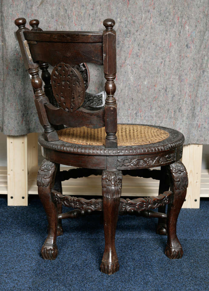Burgmeister chair with cane seat and heavily carved wood with floral decoration.
