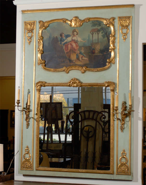 This is a lovely French Trumeau mirror with a French scene painted above the mirror framed with a gilded frame.  The gilding continues on both sides drawing your eyes down to the mirror which is also gilded.  The sconces were added at a later date. 