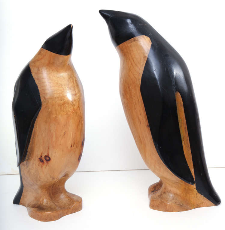 These charming penguins are hand-carved in wood (most likely pine as they are on the lighter side). They have a very Art Deco look to them due to the way they are painted. These are very large, the taller one stands 21