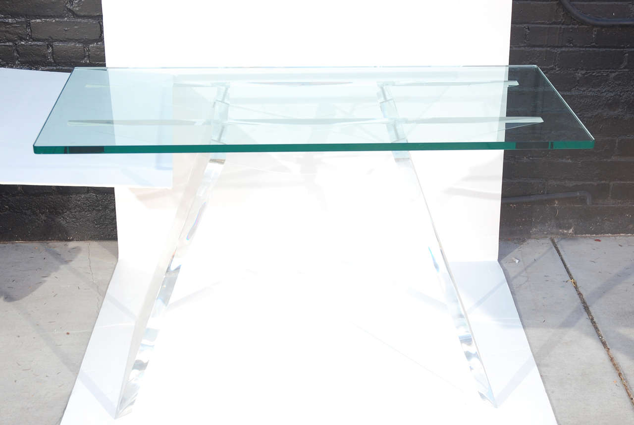 Lucite console table with glass top. Splayed leg lucite base with 1 inch thick glass top.
