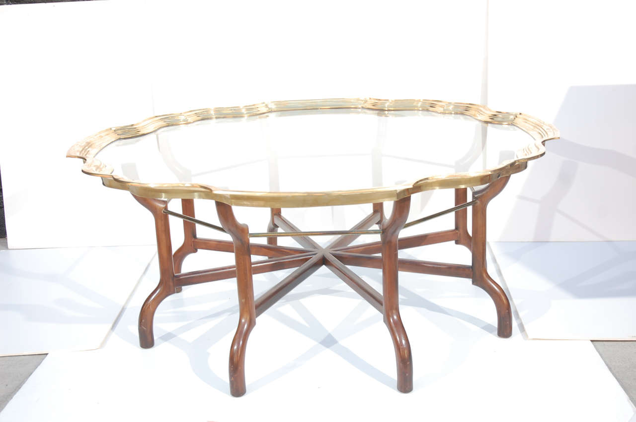 Brass framed piecrust glass top table on wood and brass trestle base.