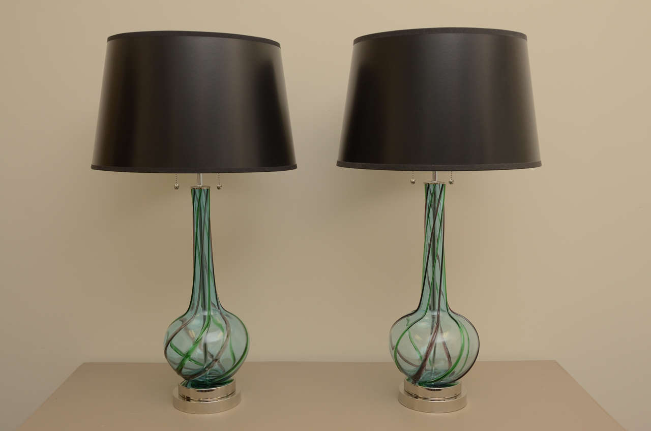 Wonderful pair of large blue Murano glass lamps with stripes of green and amethyst swirls. The lamps have been newly rewired with adjustable nickel double clusters and are mounted on stacked nickel bases. Shases are not included