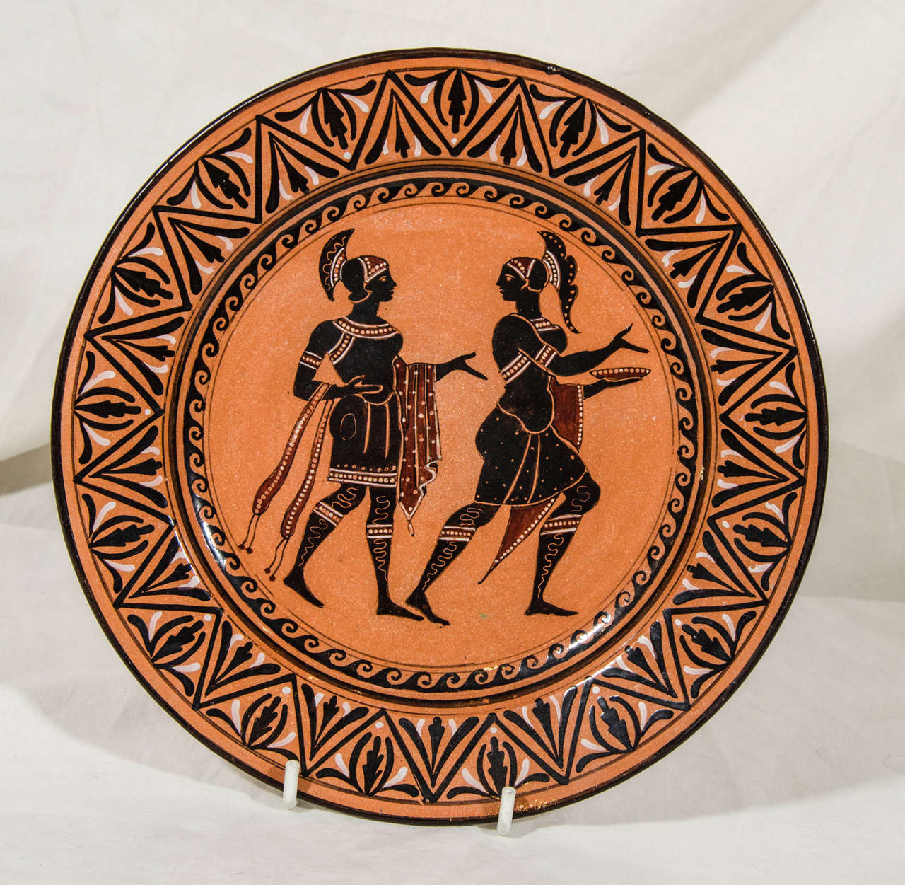 Painted with Roman figures in black, white and brownish red on a glazed terracotta ground. Made in the factory of the Giustiniani family which began making fine ceramics in Naples in the 18th century.