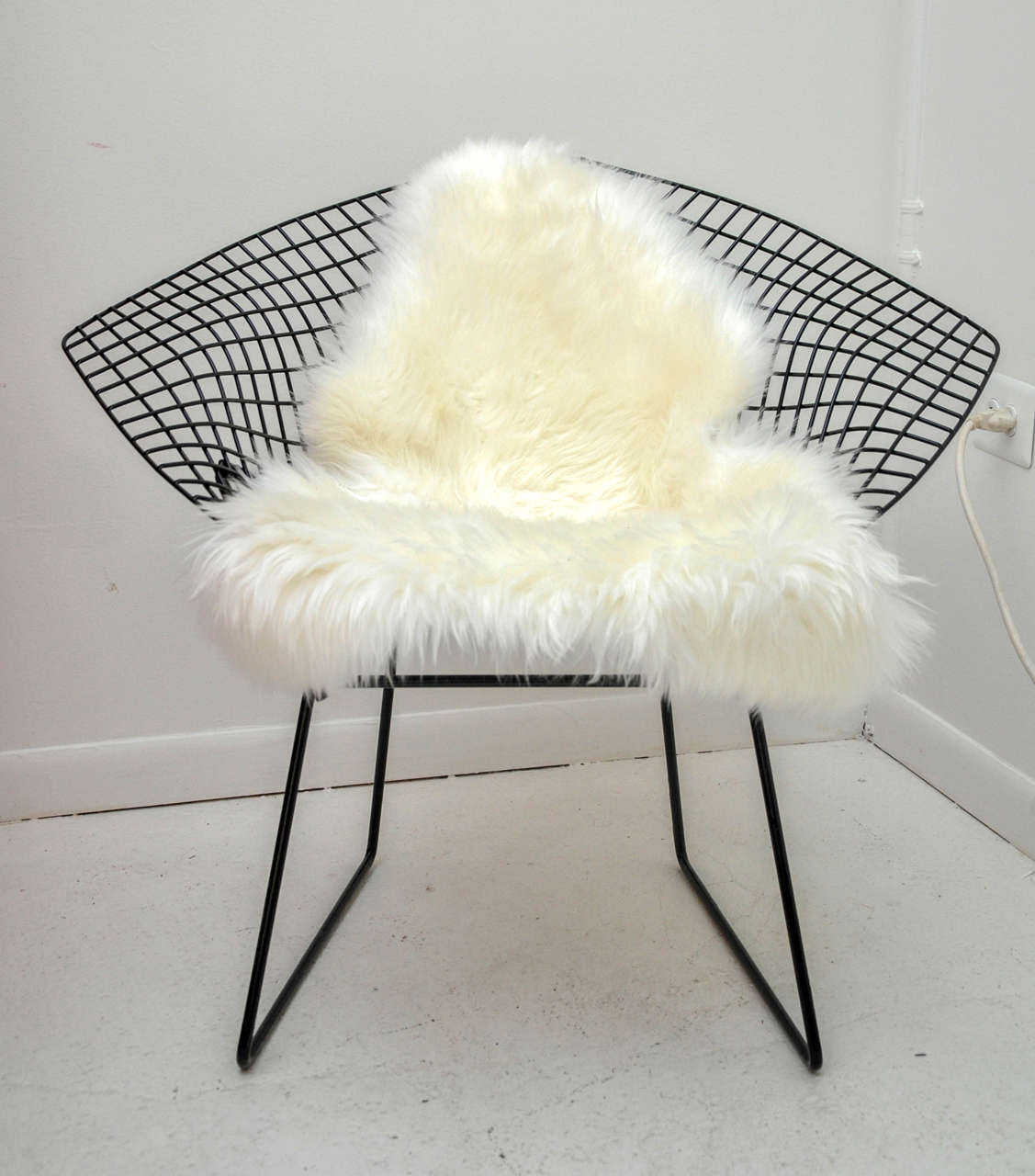 The graceful Diamond Chair is an astounding study in space, form and function by one of the master sculptors of the last century Harry Bertoia. Adorned with fabulous sheepskin for added comfort.