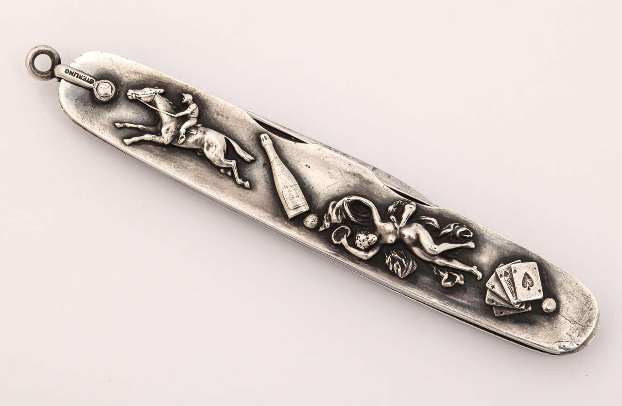 A very rare sterling silver and steel gentleman's pocket knife depicting the four vices of man; horses, alcohol, women and gambling. A wonderfully detailed example of a popular series of items with this type of topic being shown.

The blades were