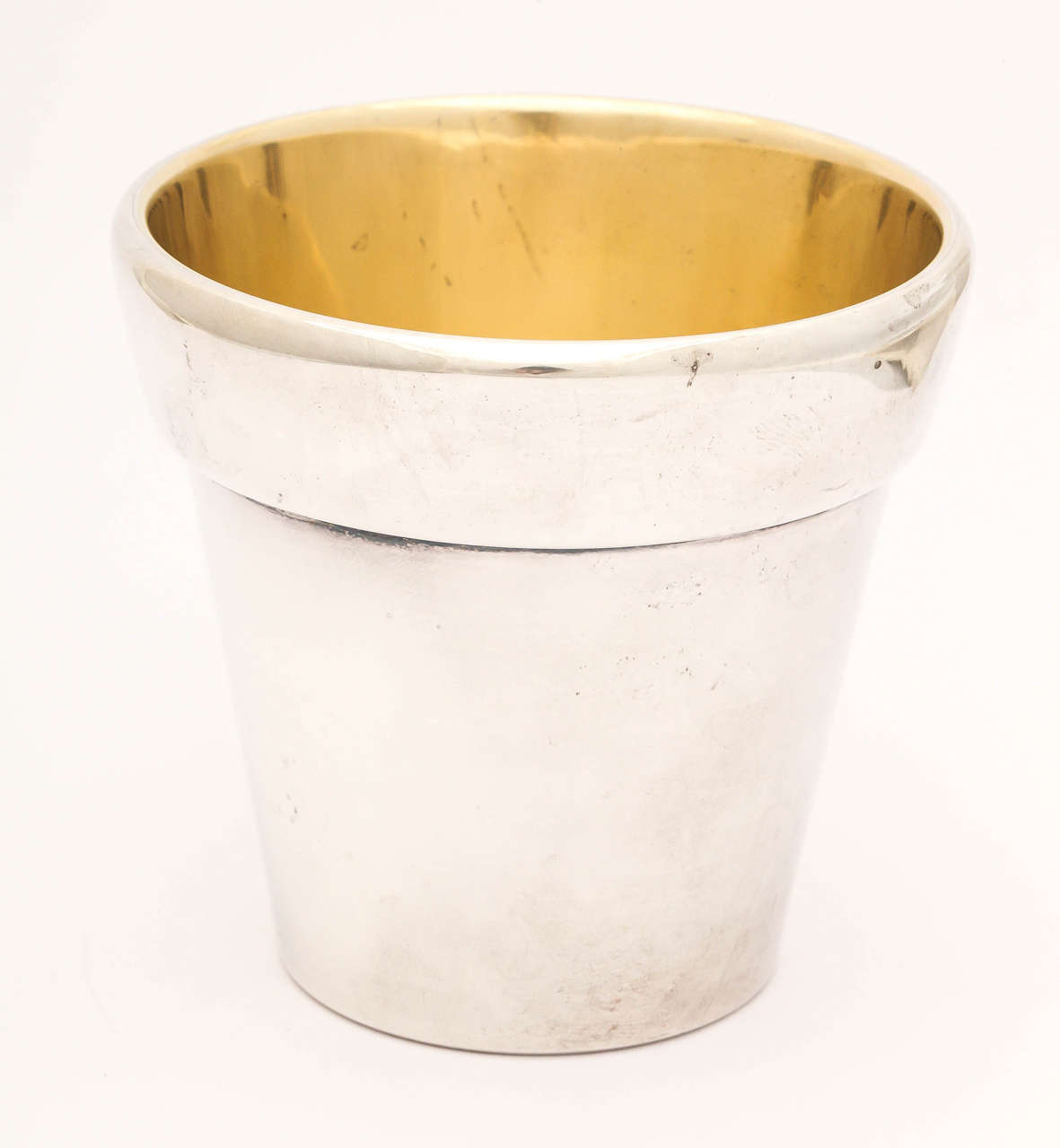 A whimsical study of a traditional terracotta flower pot made in sterling silver with a lemon gilding on the interior. The piece is incredibly heavy, being made in an exceptionally thick gauge of silver.

The piece has full marks for Bulgari and