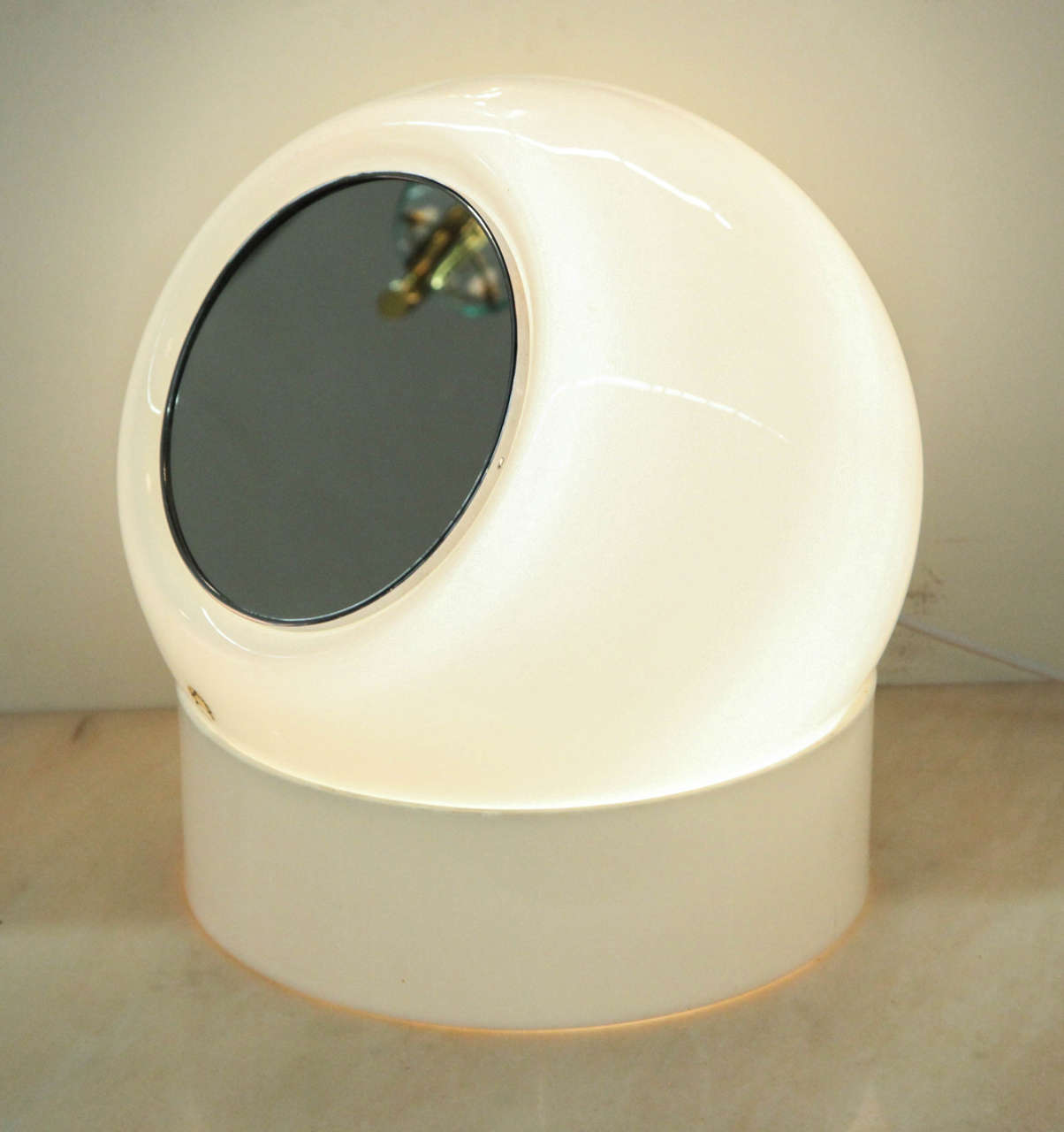 Fabulous modernist lamp made in Milan in the 1960s by Leucos. White glass shade with a mirror in front on a adjustable white Plexiglas stand still retaking the original label, very rear to find such a piece.
 