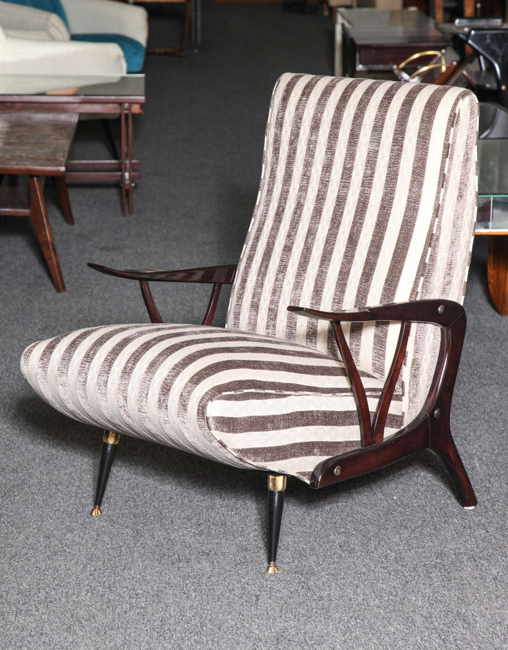 Stylish pair of armchairs made in Milan 1955, wonderfully carved biomorphic wood arms and back legs front, legs in steel with brass sabots, very unusual design, very comfortable.