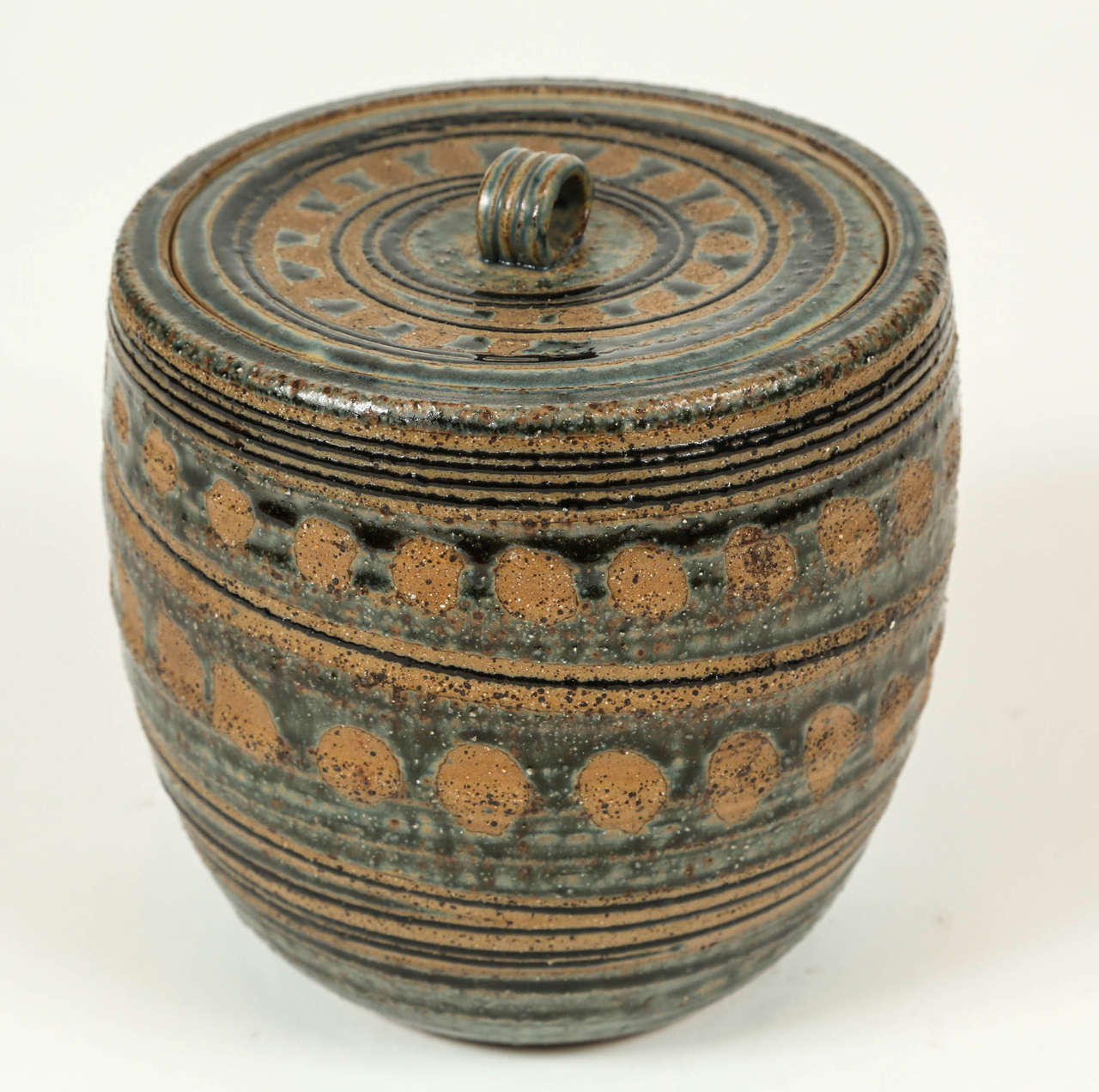 Vintage lidded pottery jar with geometric pattern and gloss blue glaze with matte underglaze.