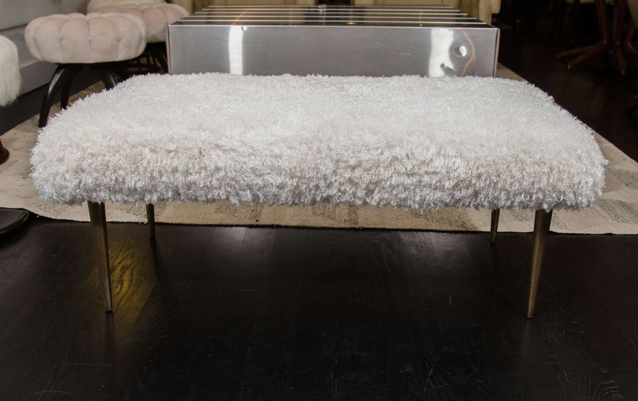 Faux Mongolian lamb fur covered Mid-Century bench. Wood frame with brass base.