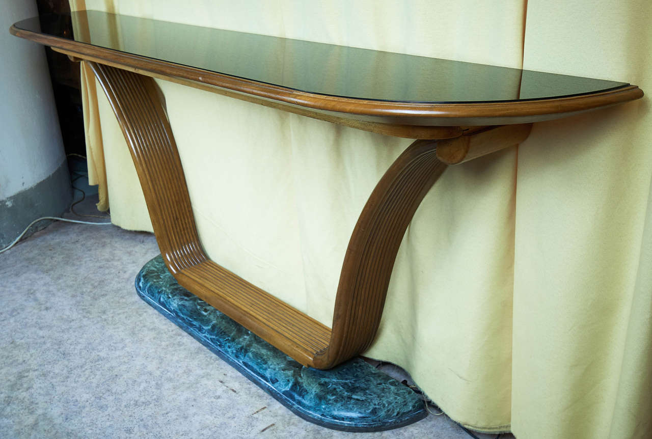 Solid walnut sculptured and grooved with built in black opaline glass.
The base is on demilune marble.

