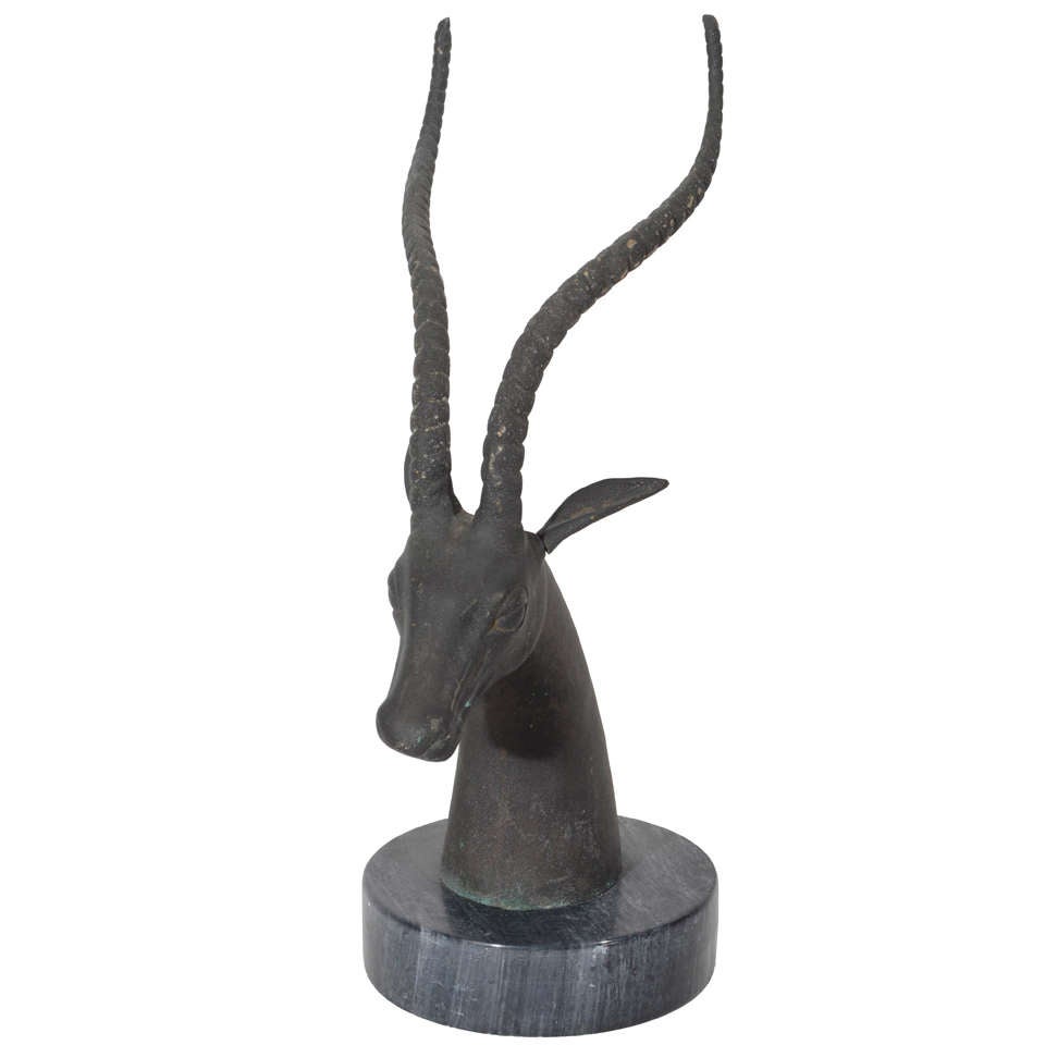 Mid-Century hand-forged bronze sculpture of stylized gazelle or ibex, with patinated and blackened finish. Sculpture has a hand polished exotic marble base in hues of black with grey veining. Excellent desk accessory or tabletop object.