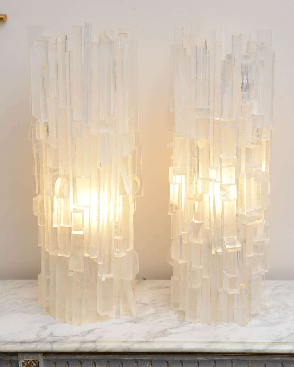Living Artist Cleo Renaut has created those Lamps from 
Thick Lucite Pcs of the 1970' Era.
They are 100% hand Made by Her.
The Single light bulb socket is in the middle of the Lucite shaft
and give out more than adequate Lighting.