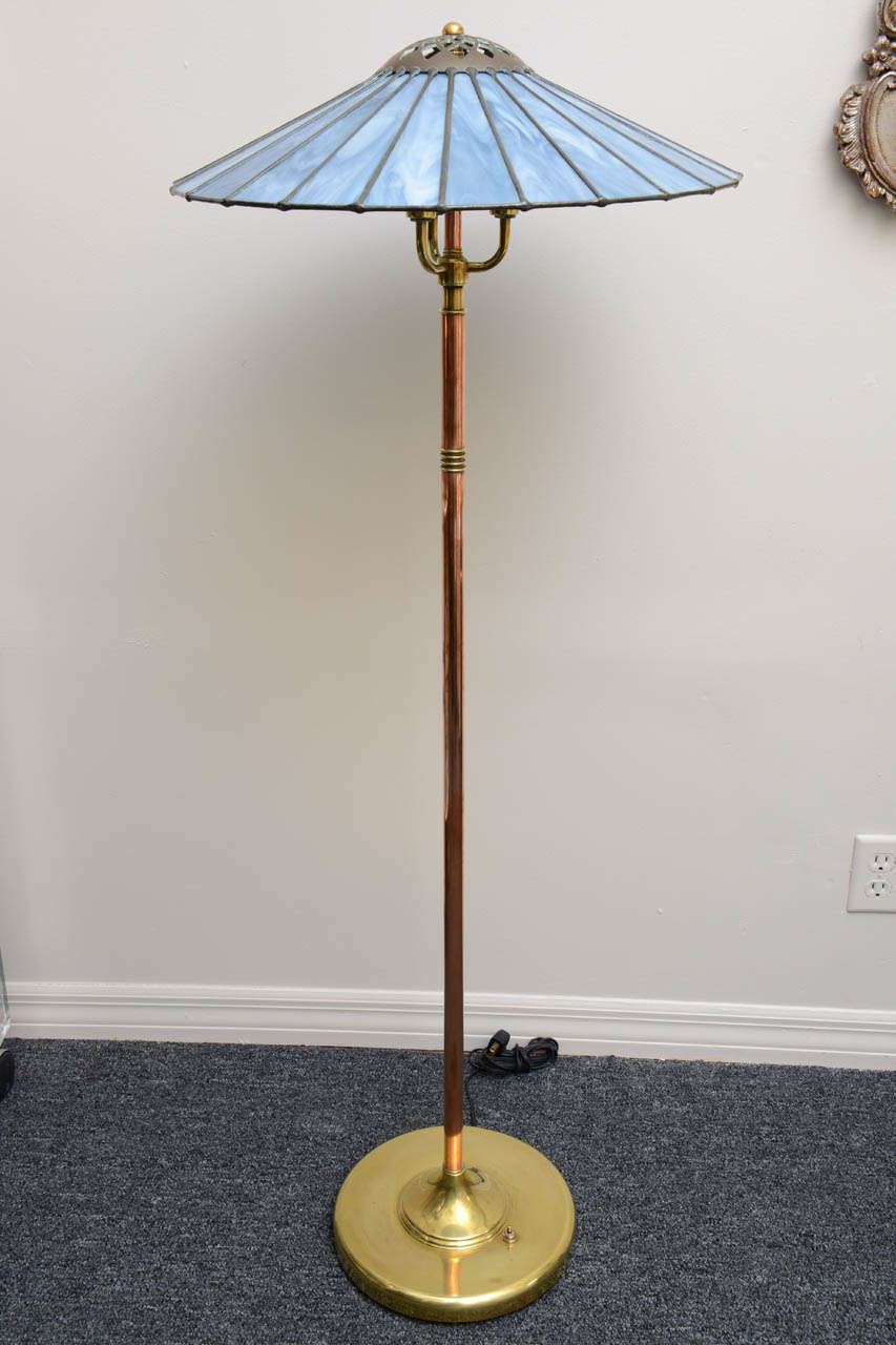 Striking copper and brass arts and crafts floor lamp with elegant leaded glass shade.