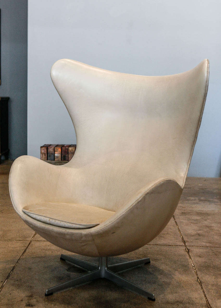 a vintage egg chair in it's original off-white leather , produced in 1970.