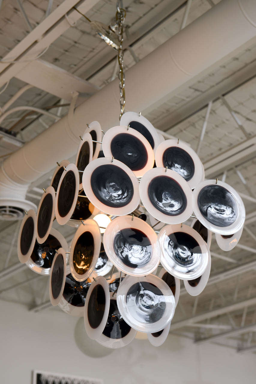 An unusual combination of dark - almost black - eggplant and milky white Murano glass disks gives this nicely scaled Vistosi chandelier a very graphic quality. 8 sockets, U.S. wiring.