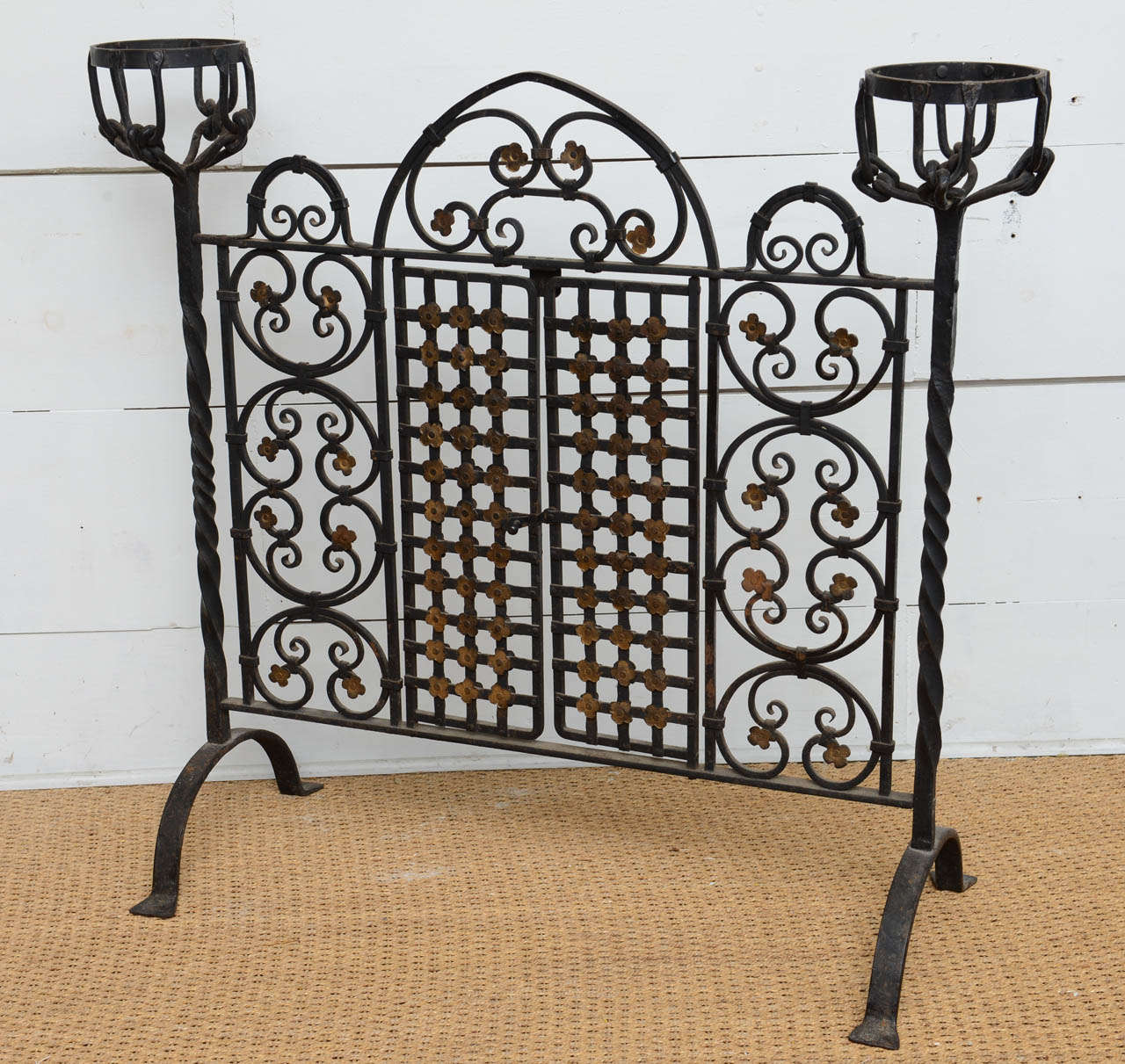 Wrought and forged iron firescreen with gates for fireplace access. Florets highlighted in gold