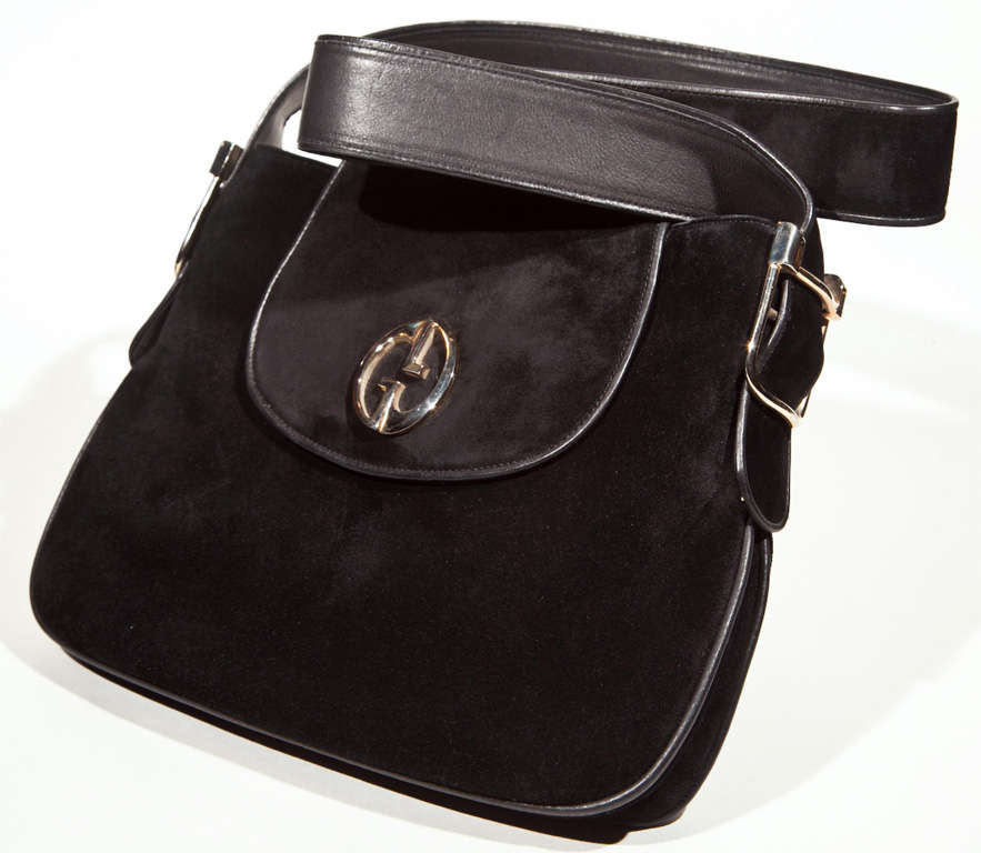 C.1970s Vintage Gucci Bag Featuring Limited Edition Logo. It boasts both a silver 'and' gold 'GG' medallion as its centerpiece. This scoped-for 'gucci 73' hardware was reintroduced by the fashion house in 2010. You'll find a luxury black suede