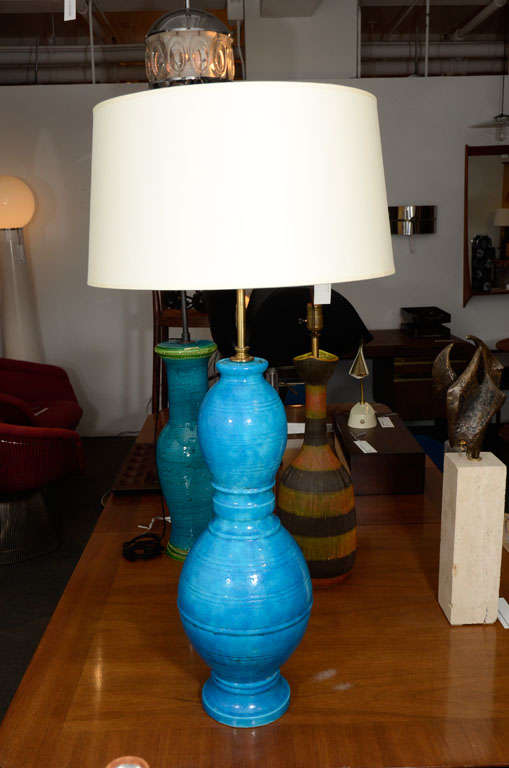 Lámpara de mesa azul de Raymor.  Italia, hacia 1950.

Presenta un vibrante vidriado azul con anillos incisos.  Recableado con alambre trenzado de seda negra francesa.

Dimensiones:
37 pulgadas de alto
22,75 pulgadas hasta el cuello (parte