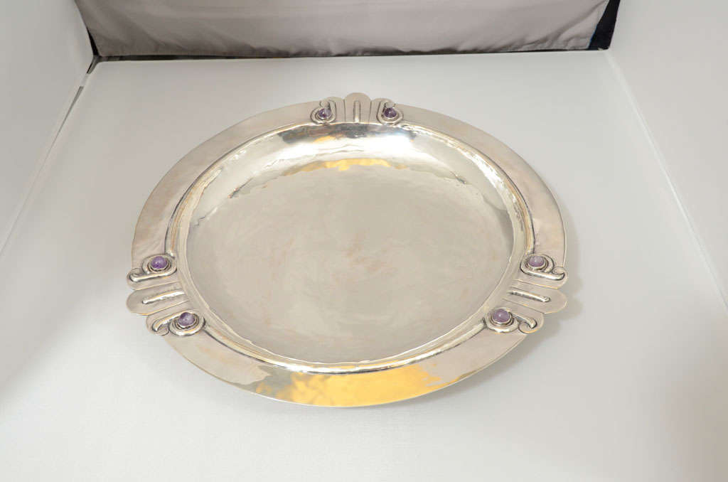 A sterling silver bowl by William Spratling with three incised loop patterns and cabochon amethysts decorating three sides.   Hallmarked.  Hand hammering evident.