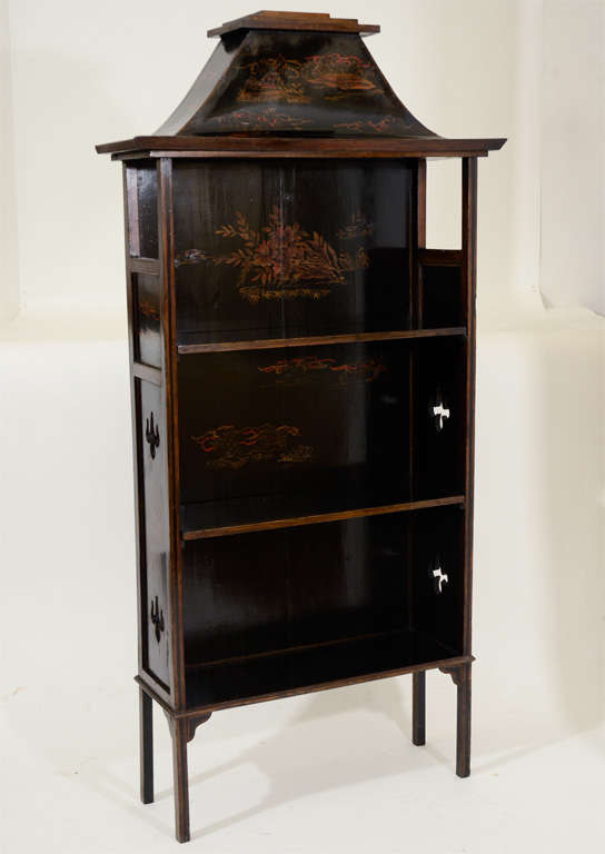 Vintage Narrow Black Lacquer Chinoiserie Pagoda-Shaped Bookcase, Decorated in Foliate Design with Two Shelves; <br />
Raised on Straight Legs.  England, c. 1925<br />
<br />
25.5 inches wide x 9 inches deep x 53 inches high