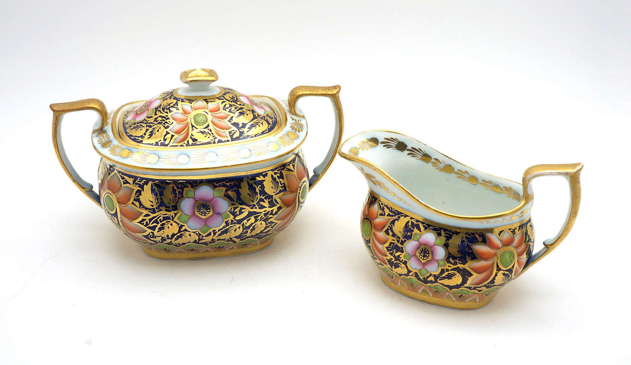 This might be one of the prettiest Imari patterns available! This is a 5 piece unsigned Spode Imari teaset with all-over floral decoration on cobalt ground and gilded overlay. Besides the teapot, creamer and sugar, this also includes the tea trivet