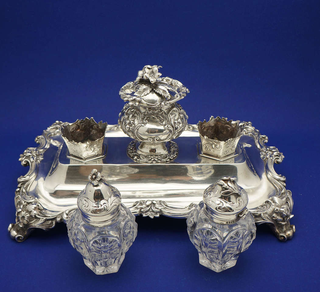 This lovely 19th C. English Silver double inkwell is the perfect desk accessory for the discerning collector. Made in 1839, the cut glass ink bottles are topped with floral finials and sit inside 5-sided fitted stands. The base is large and well