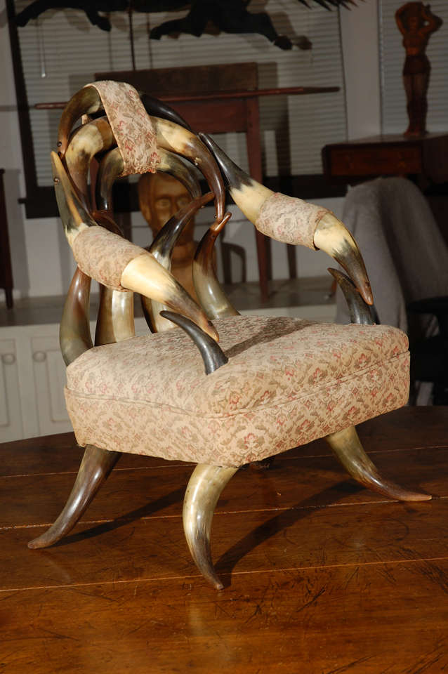 Offering a rare c. 1900 child's 20 cow horn frame upholstered chair. This is a rare piece indeed, as the number of horns determines the rarity, with this many never seen by most collectors. It is American, has a wood bottom, and was reupholstered in