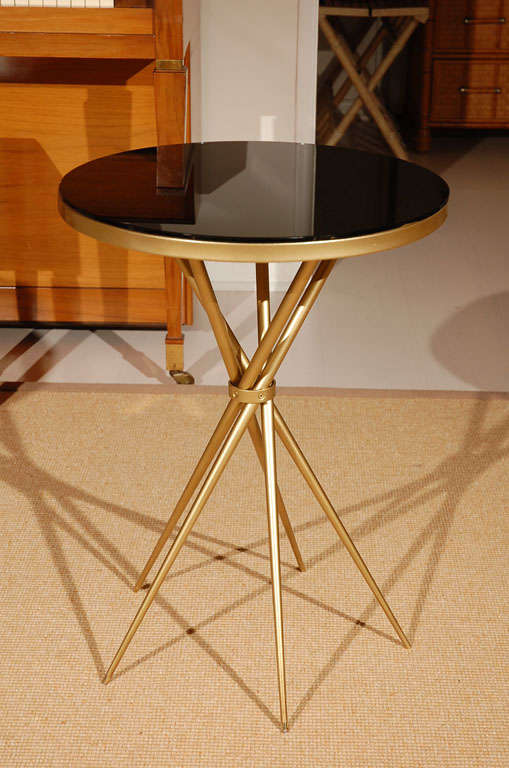 A beautiful Art Deco design, this brass side table is petite and sophisticated, fitting in between a pair of side chairs perfectly or alongside a single reading chair. Truly elegant, the criss-crossing of the base, banded together in the center,