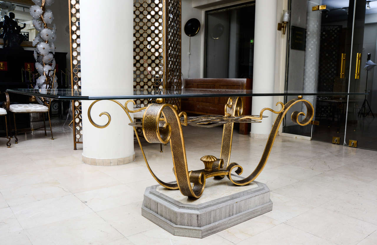 Very big Dining table, 6 chairs and 2 armchairs in wrought iron.
Brown and gold patina.
Base in marble.
Rectangular top in glass.
New upholstery on the chairs with a beige satin  .
Made during the 1970s in the style of Poillerat.