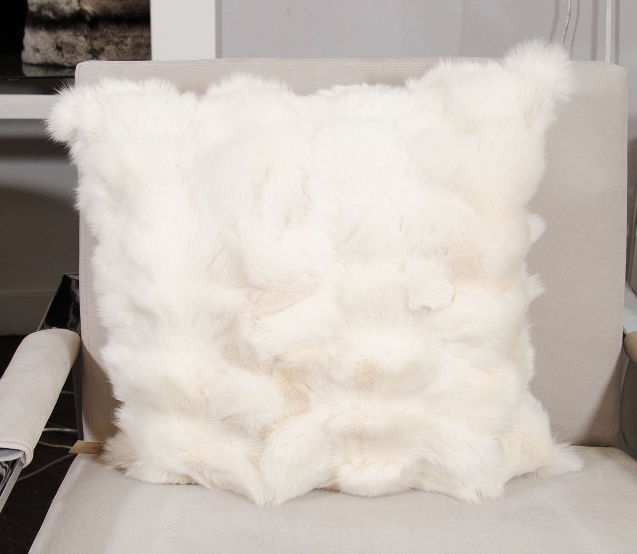 White pieced fox pillow with leather backing.