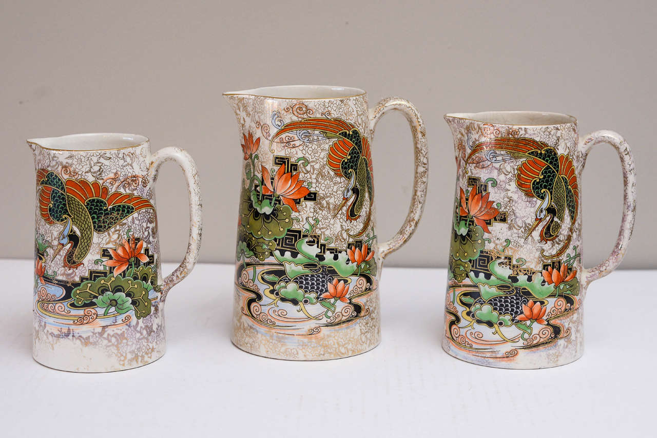 Set of Three English Phoenix Ware Jugs, Circa 1925; each in imari color palette with gilding. Heights: 7.5 in., 7 in. & 6 1/4 in. Made by Thomas Forester & Sons