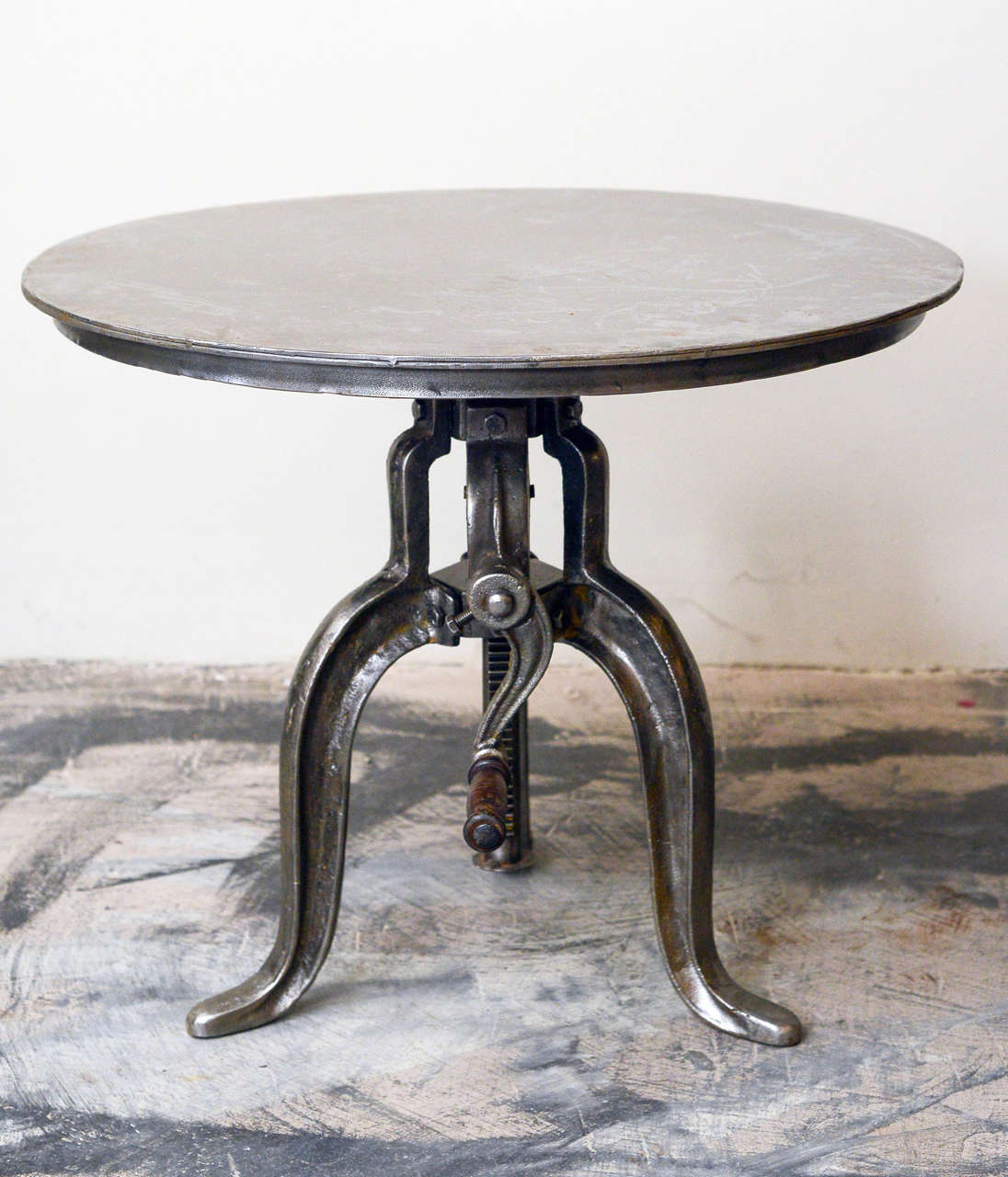 Industrial iron circular adjustable table, circa 1900, height adjusts from 18.5 to 26.75 inches. Would make an excellent drinks, coffee, or end table.