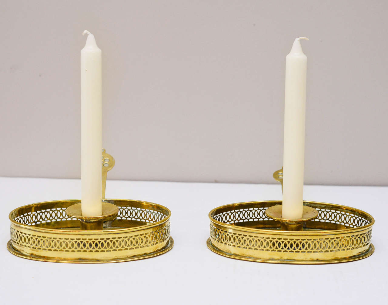 Pair of English pierced brass candle holders, mid-19th century with applied pierced handles
