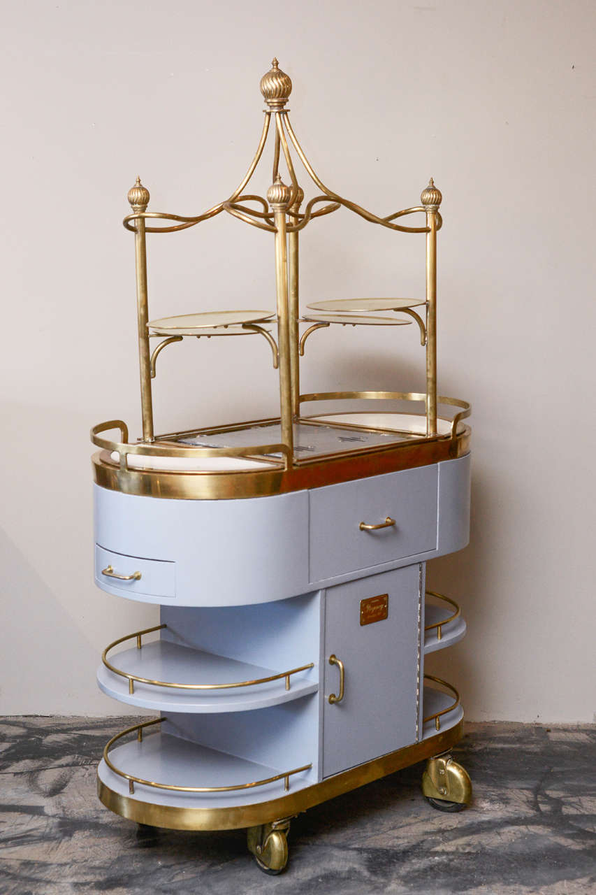 American, Art Nouveau style brass, stainless steel, Lucite and painted food cart, mid-20th century with two cutlery drawers and small cutting board, and two sterno burners. Labeled: 
