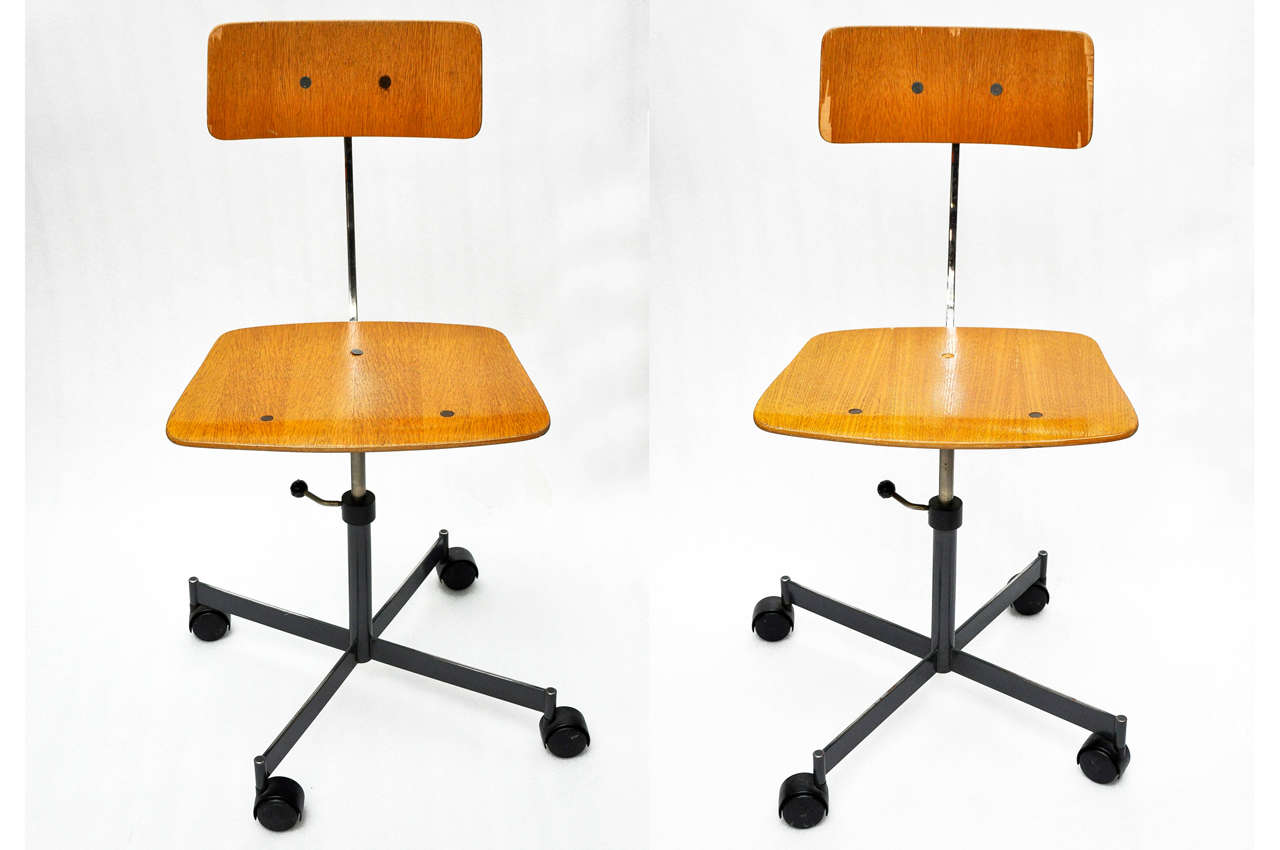 A pair of 1950s French Industrial school or office side chairs on casters, made of formed plywood and painted metal. Height is adjustable.